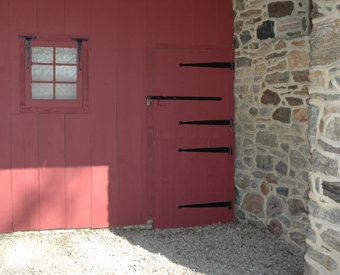 Red Dutch barn door hung on long forged strap hinges