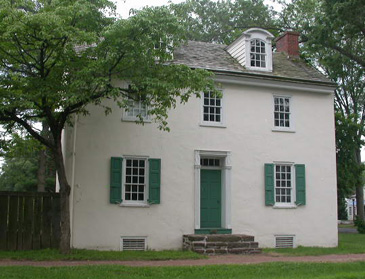 Stucco colonial with green shutters