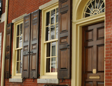 Louvered shutters on a brick facade
