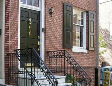 Townhouse entry with black shutters