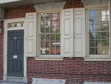 Brick house with white paneled shutters