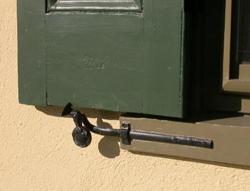 Forged slide bolt on a green shutter