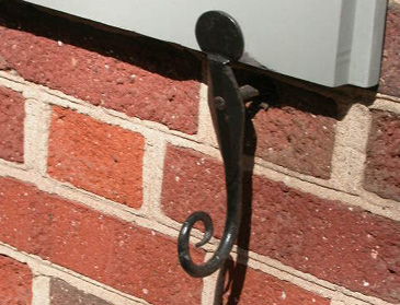 S-shaped shutter dog on red brick